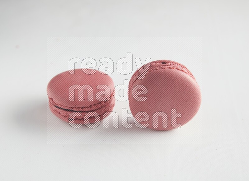 45º Shot of two Pink Raspberry macarons on white background