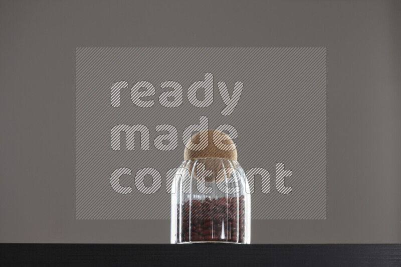 Red kidney beans in a glass jar on black background