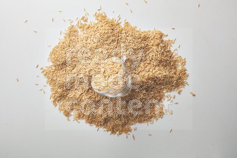 Top-view shot of long grain brown rice in a container on white background