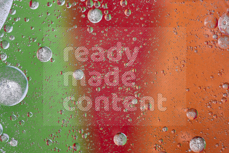 Close-ups of abstract oil bubbles on water surface in shades of orange, green and red