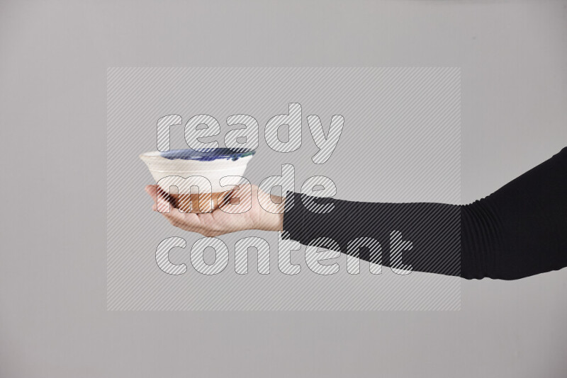 A woman in black abaya holding different pottery essentials in different positions
