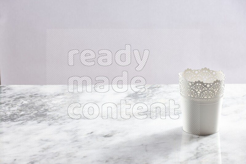 An empty white plant pot on grey marble background