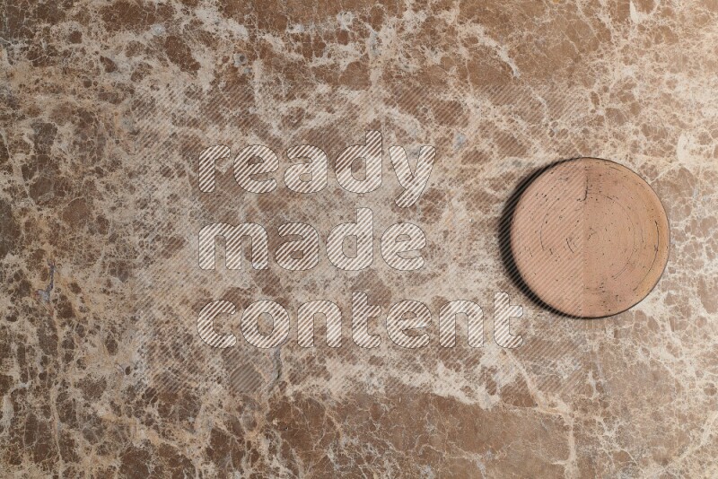 A pottery coaster on beige marble background
