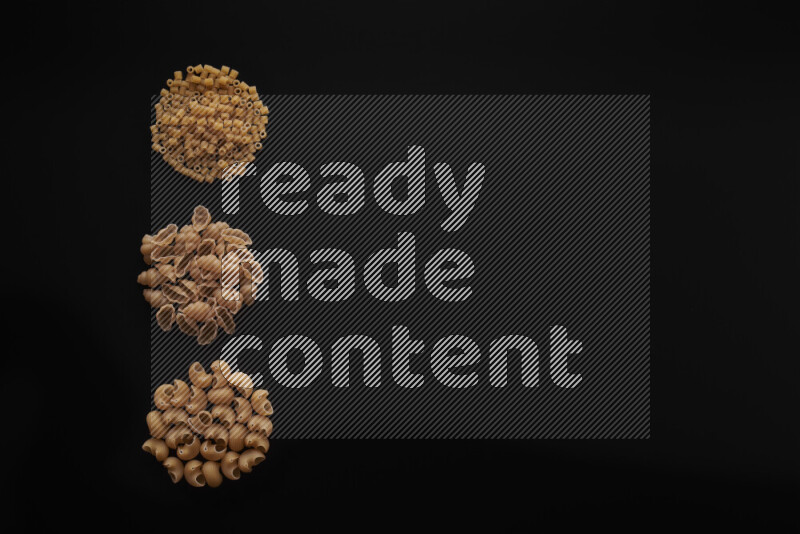 Different pasta types in 3 bunches on black background