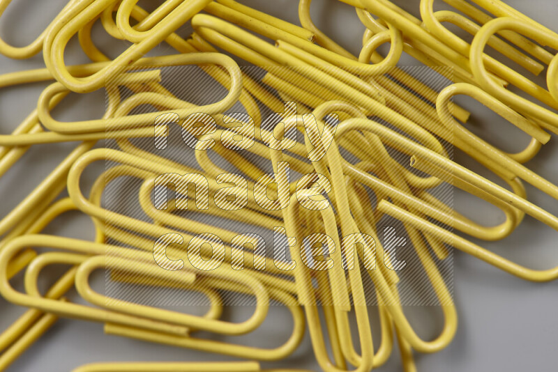 Yellow paper clips isolated on a grey background