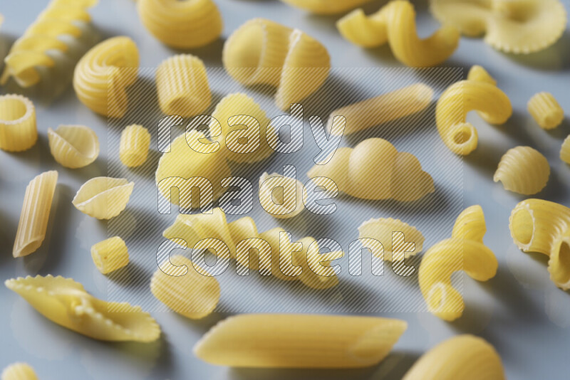 Different pasta types on light blue background