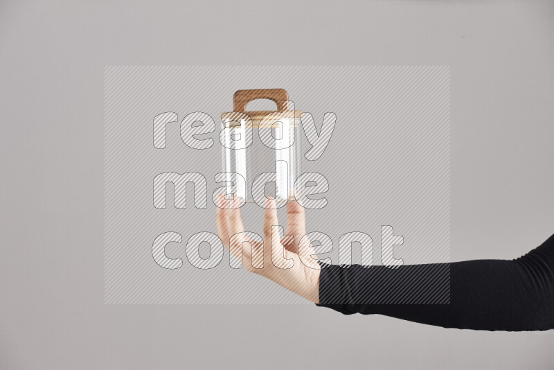 A woman in black abaya holding different glassware in different positions