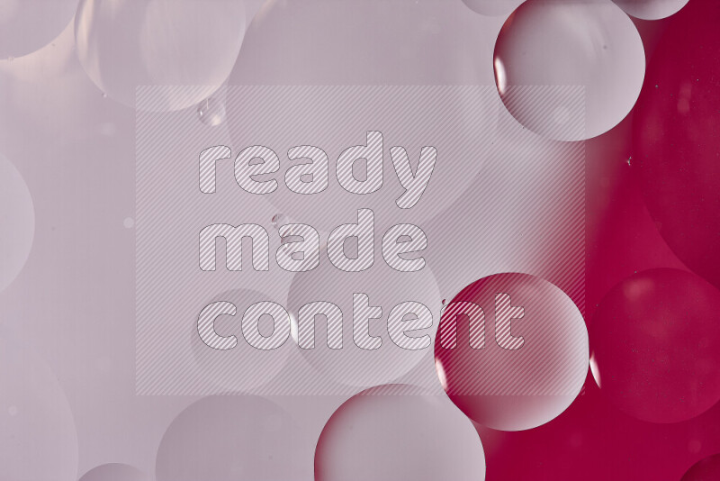 Close-ups of abstract oil bubbles on water surface in shades of white and pink