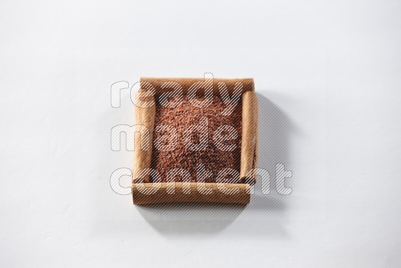 A single square of cinnamon sticks full of garden cress on white flooring