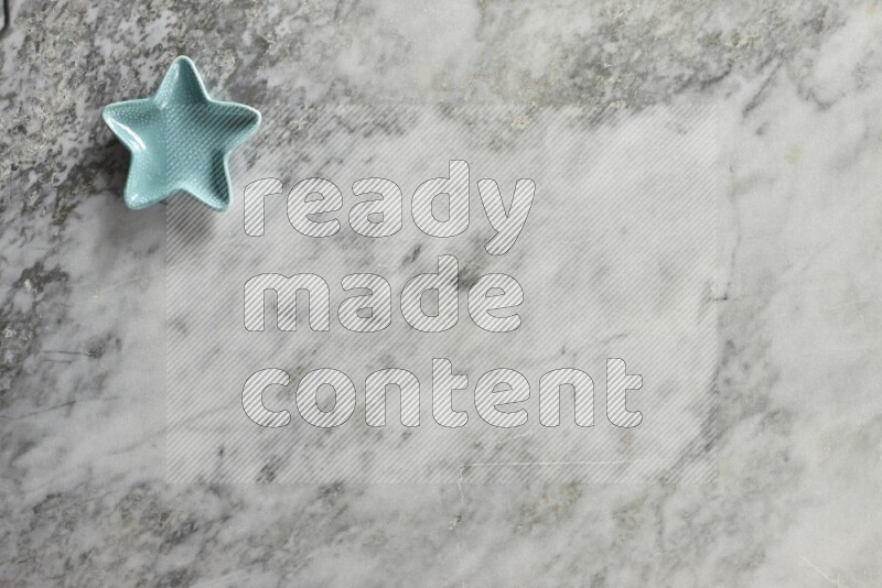 A colored pottery star plate on grey marble background