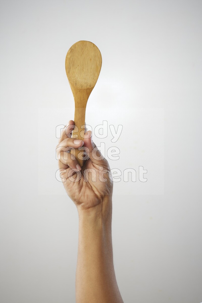 Male Hand Holding Wooden spoon on white background