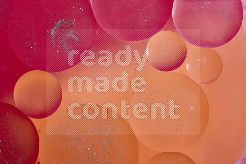 Close-ups of abstract oil bubbles on water surface in shades of red, orange and pink