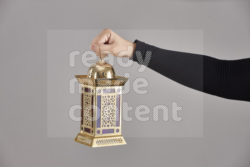 A woman in black abaya holding different ramadan lanterns in different positions