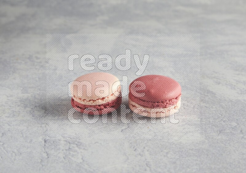 45º Shot of two Pink Litchi Raspberry macarons  on white  marble background