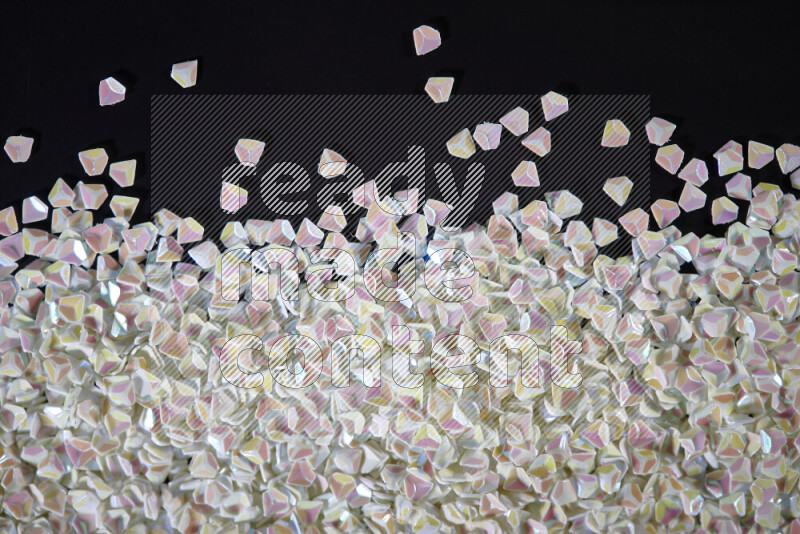 Colorful plastic shards for decoration scattered on a black background