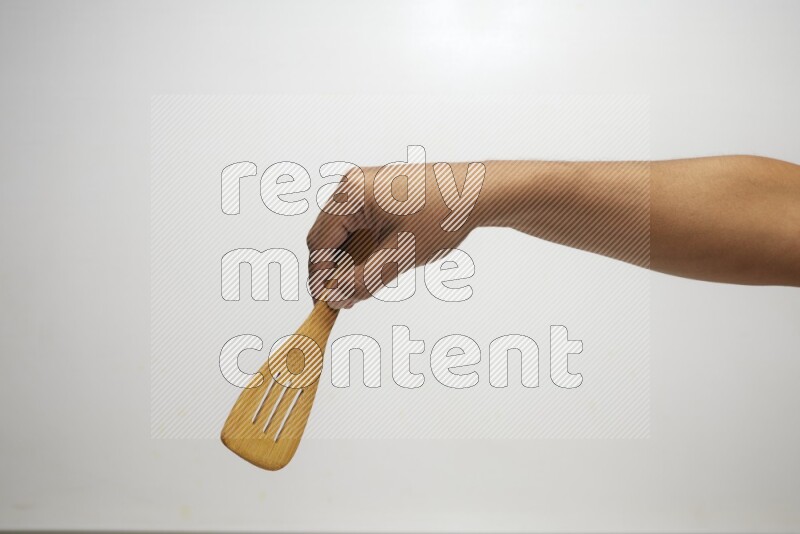 Male Hand Holding Slotted Turner on white background
