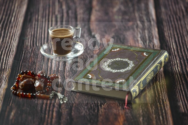 Quran with dates, prayer beads and different drinks all placed on wooden background