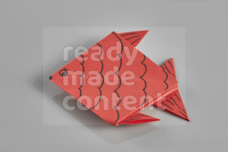 Origami fish on grey background