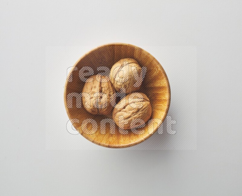 Top-view shot of walnut in a container on white background
