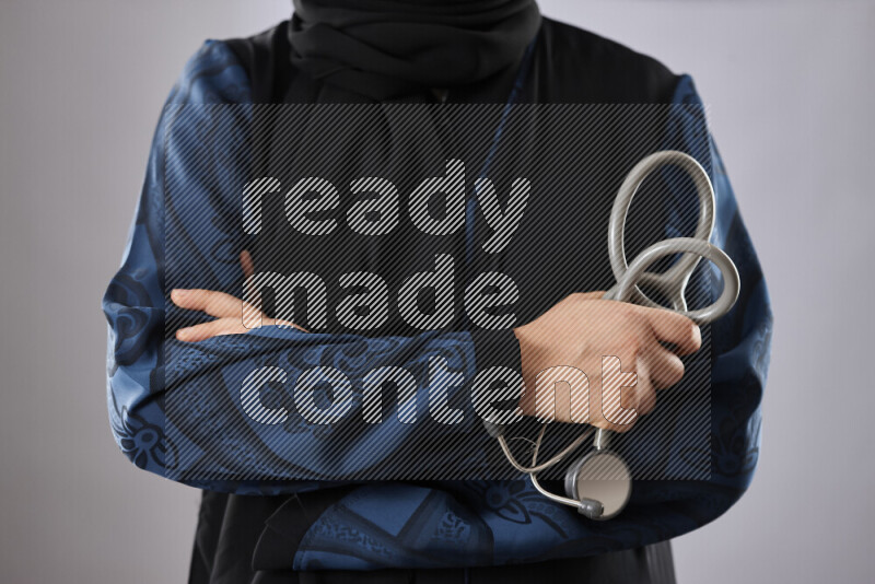 طبيبة ترتدي عباءة وملابس طبية في أوضاع متعددة