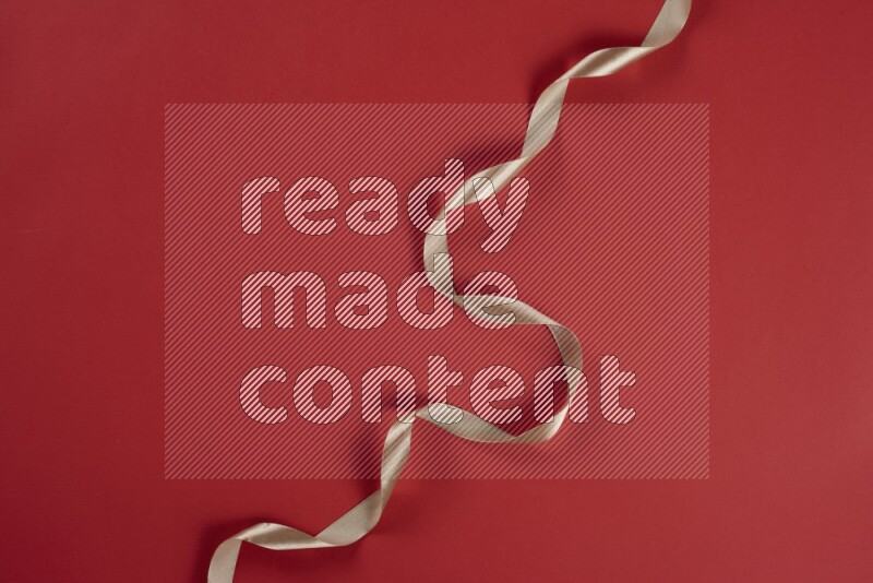 مجموعة من أدوات الخياطة والتفصيل بنية وحمراء اللون على خلفية حمراء