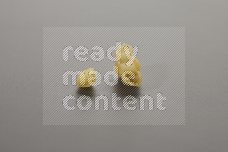 Shells pasta with other types of pasta on grey background