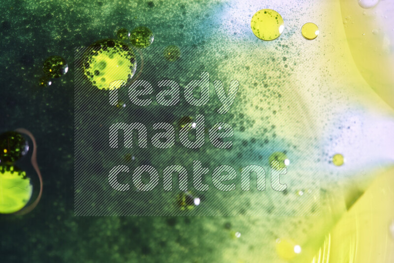 لقطات مقربة لقطرات ألوان مائية خضراء وصفراء على سطح الزيت على خلفية بيضاء