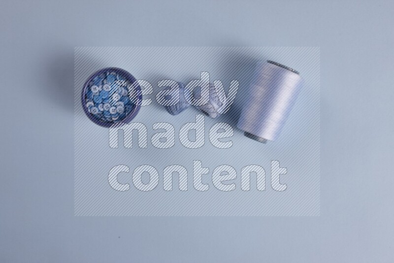 A blue collection of sewing and tailoring tools arranged on a blue background