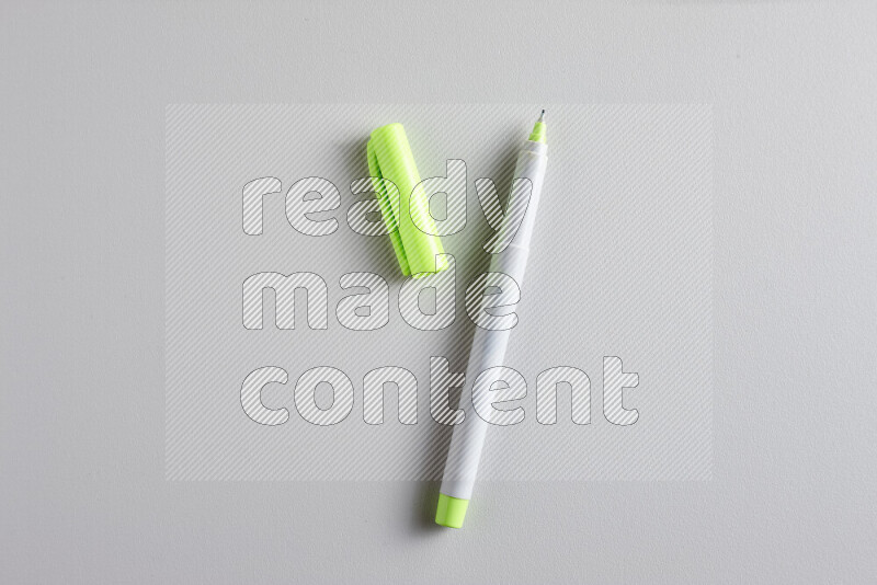A close-up showing an open single coloring pen with a cap on grey background