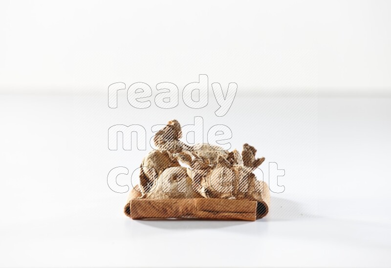 A single square of cinnamon sticks full of dried ginger on white flooring