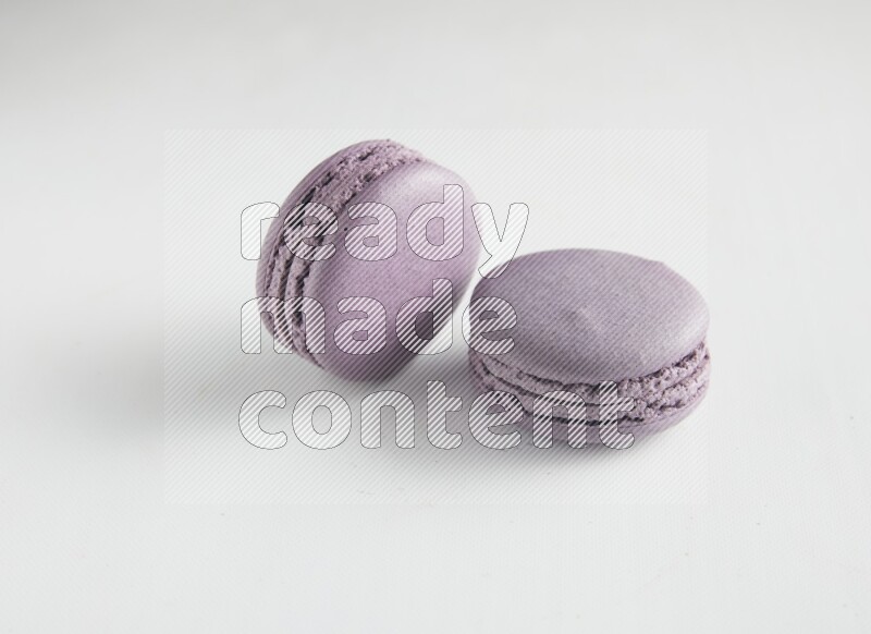 45º Shot of two Purple Blueberry macarons on white background