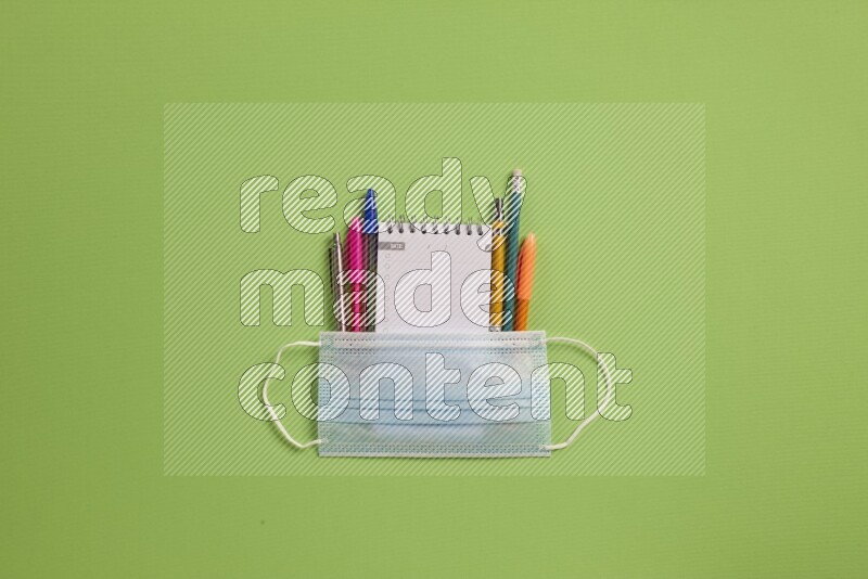 Different school supplies on green background