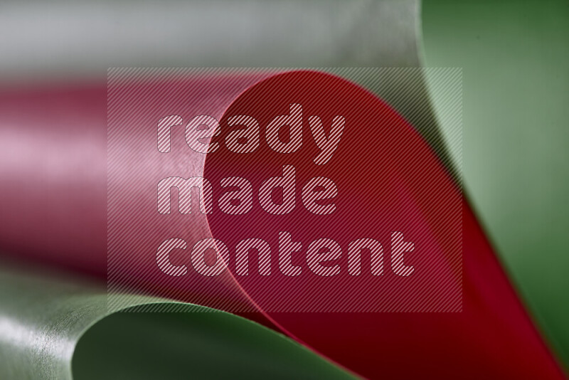 An abstract art showing red and green paper sheets arranged in an overlapping curves