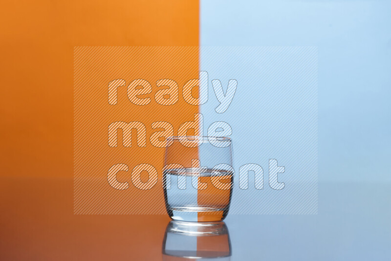 The image features a clear glassware filled with water, set against orange and light blue background