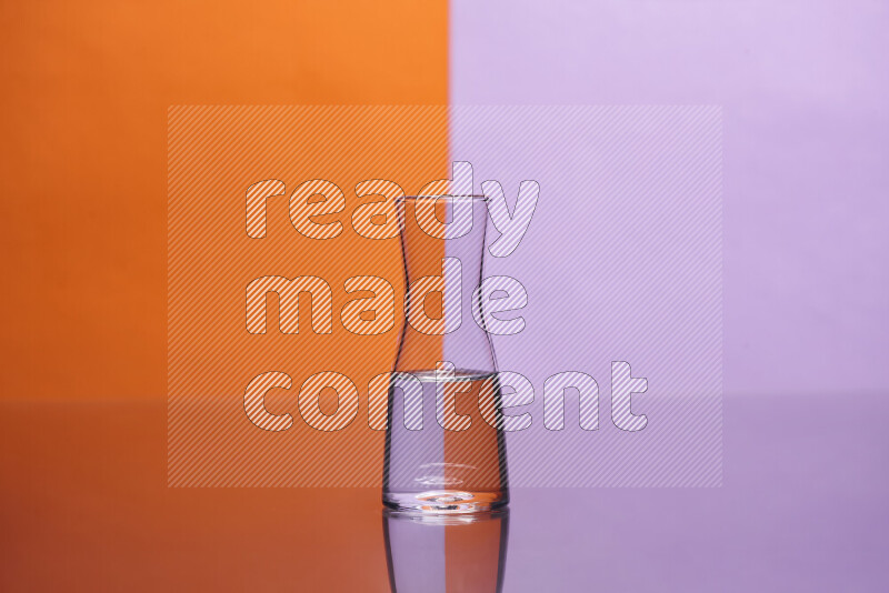 The image features a clear glassware filled with water, set against orange and light purple background