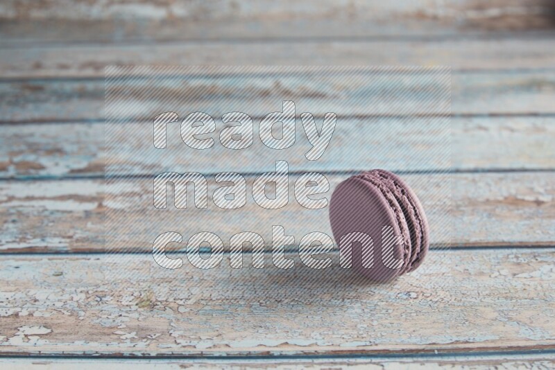 45º Shot of Purple Blueberry macaron on light blue wooden background