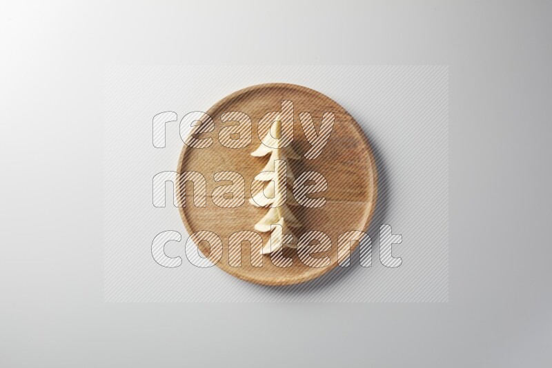 Five Sambosas on a wooden round plate on a white background