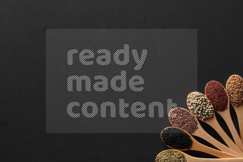 الفلفل الأسود وحبوب الخردل وحبة البركة وحب الرشاد والكمون و حبوب الكتان في معالق خشبية علي خلفية سوداء