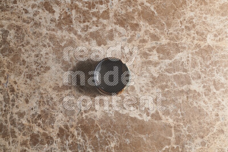 A multicolored pottery bowl on beige marble background