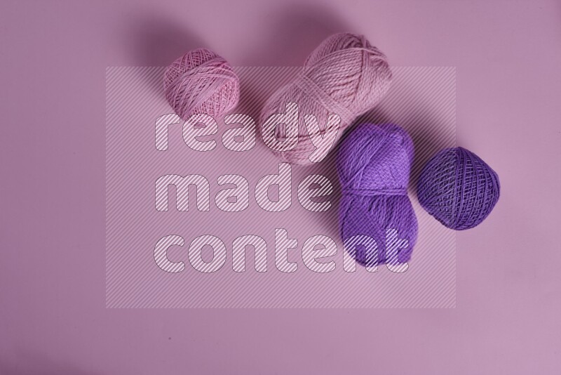 A purple and pink collection of sewing and tailoring tools arranged on a pink background