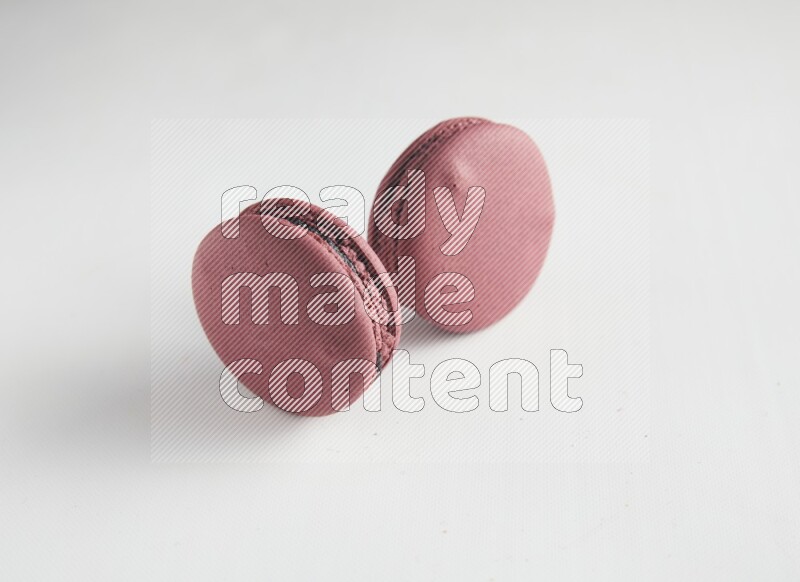 45º Shot of two Red Cherry macarons on white background