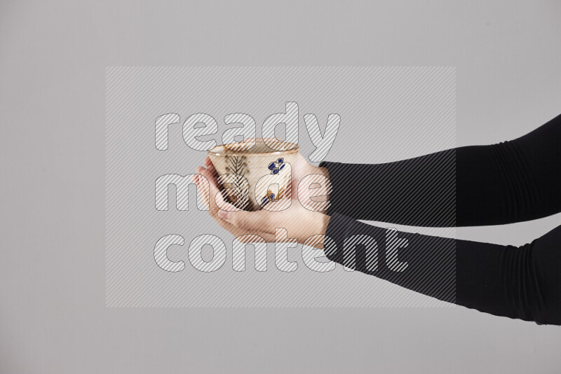 امرأة ترتدي عباءة سوداء تحمل أدوات فخارية مختلفة في أوضاع متعددة