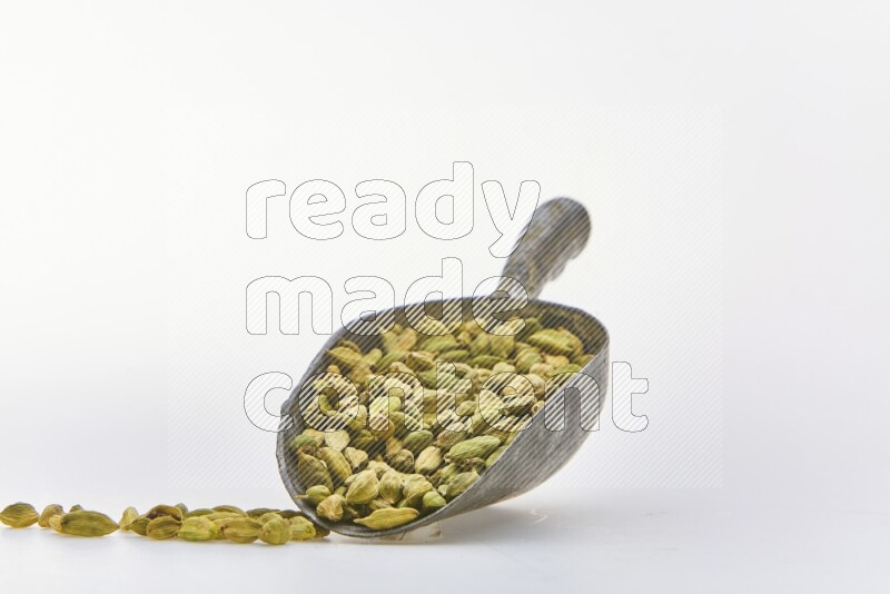 Cardamon in a shovel on white background