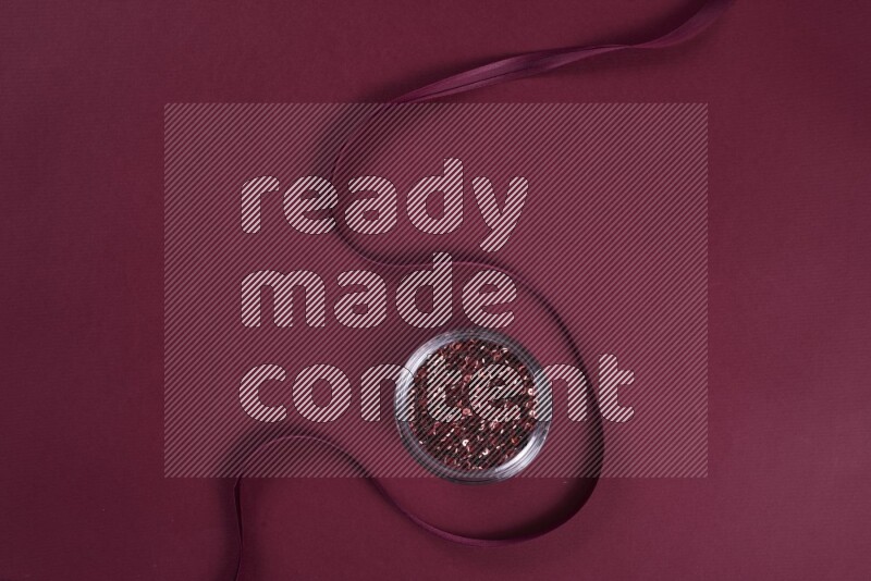 A red collection of sewing and tailoring tools arranged on a red background