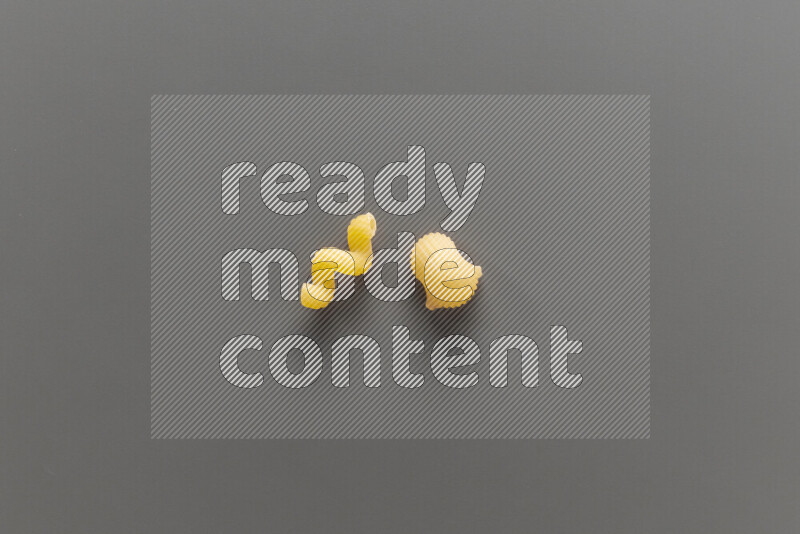 Twist pasta with other types of pasta on grey background