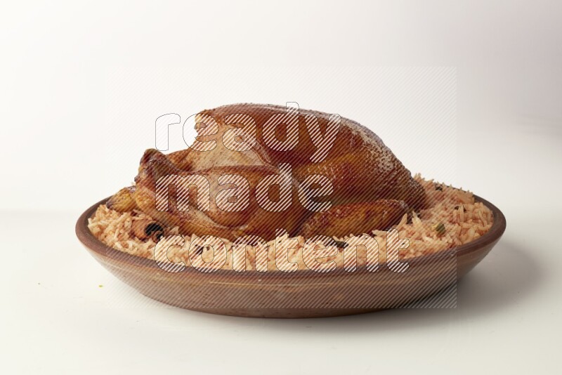 red basmati Rice with whole roasted chicken on a pottery plate direct on white background