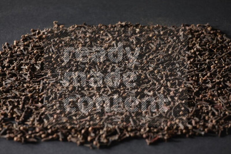 Cloves spread on black flooring