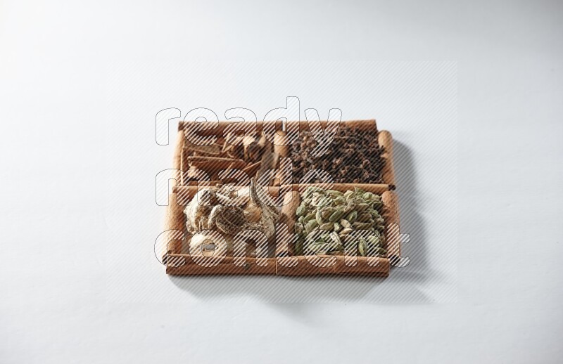 4 squares of cinnamon sticks full of cardamom, cinnamon, cloves and dried ginger on white flooring