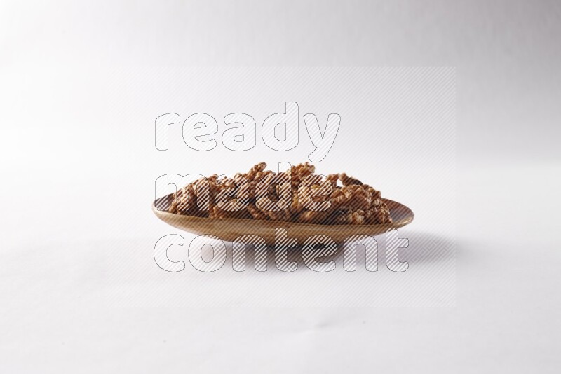 Walnuts in a wooden plate on white background