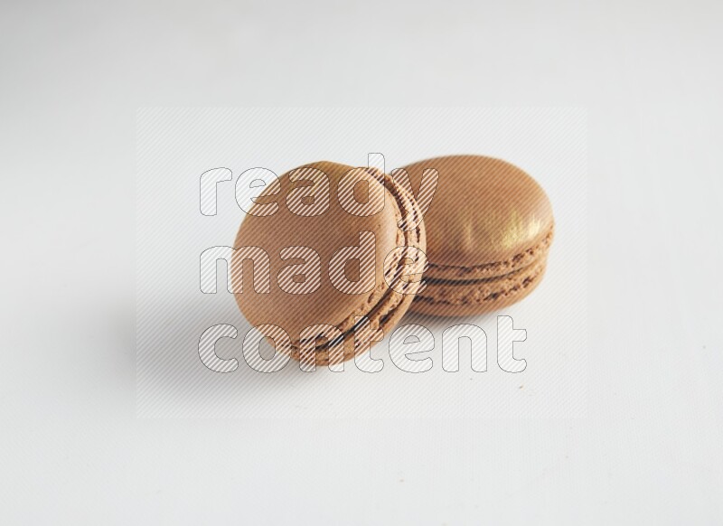 45º Shot of two Brown Coffee macarons on white background